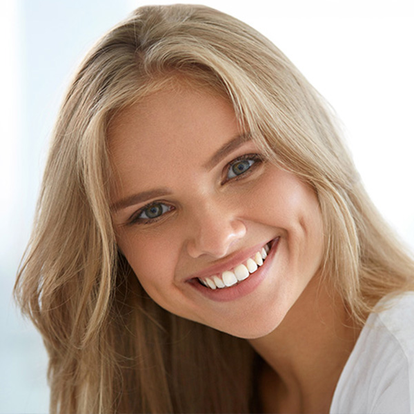 A young woman with blonde hair and blue eyes smiling at the camera.