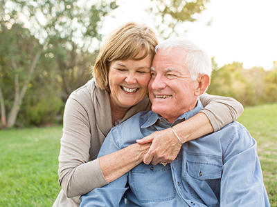 A couple embracing each other outdoors.